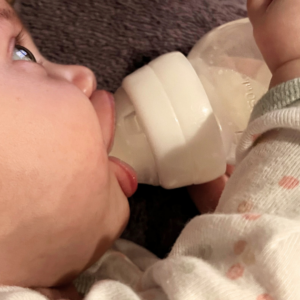 Baby drinking milk from bottle with great latch and oral function. Feeding Fundamentals Package