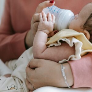 A mother feeding an infant from a bottle