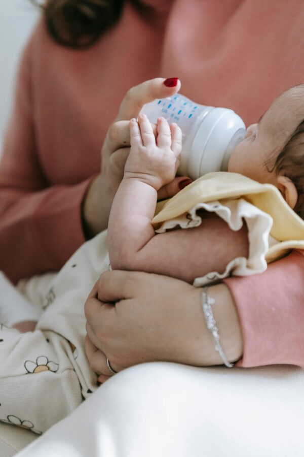 A mother feeding an infant from a bottle